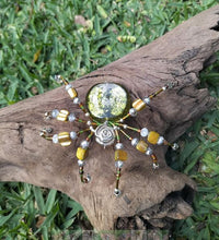 Load image into Gallery viewer, Decorative spider with beads on a piece of wood against a natural background
