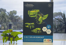 Load image into Gallery viewer, A 3-in-1 Solar Robo Kit by Australian Geographic, shown with its product packaging box and the assembled lime green robotic vehicle in the foreground, set against a blurred outdoor background.
